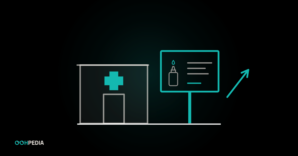 Apotheke mit grünem Kreuz neben einer Großfläche mit Augentropfen-Motiv und einem Pfeil nach oben
